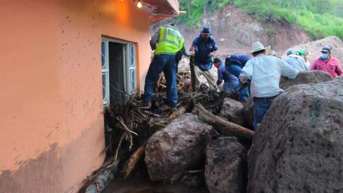 Piedras que el agua de lluvia arrastró de un cerro obstruyen la entrada de una vivienda en una comunidad de Jalpa, Zacatecas